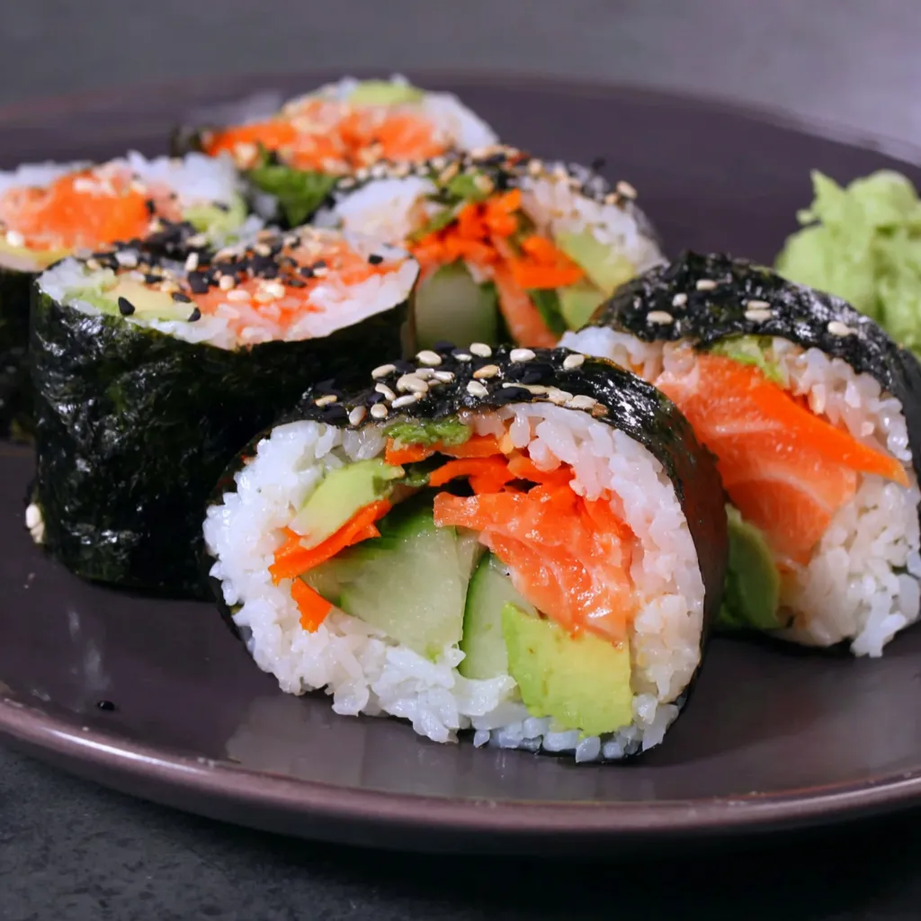 A plate of sushi with salmon and avocado.